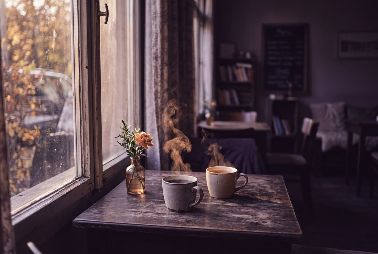 Gemütliches Café mit zwei dampfenden Tassen am Fenster